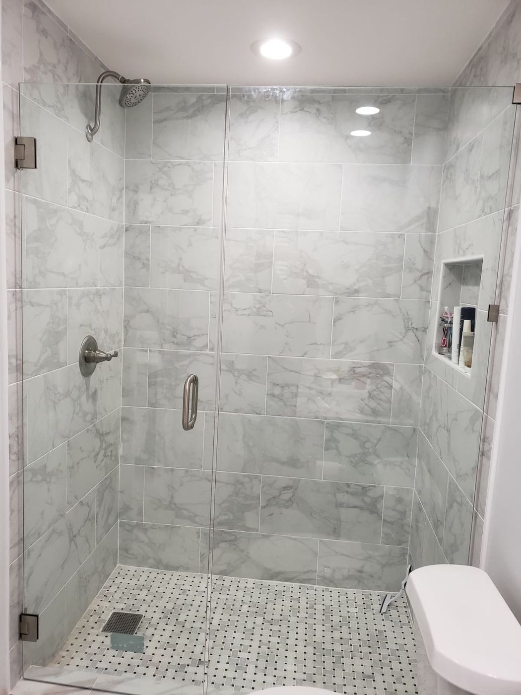 Marble-look walk-in shower with glass