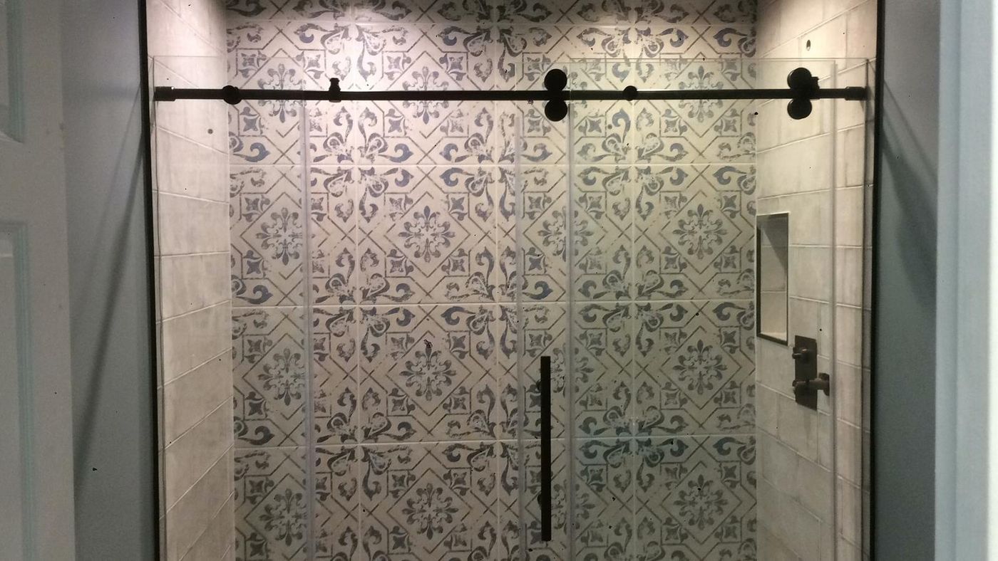 Patterned tile shower with sliding glass door